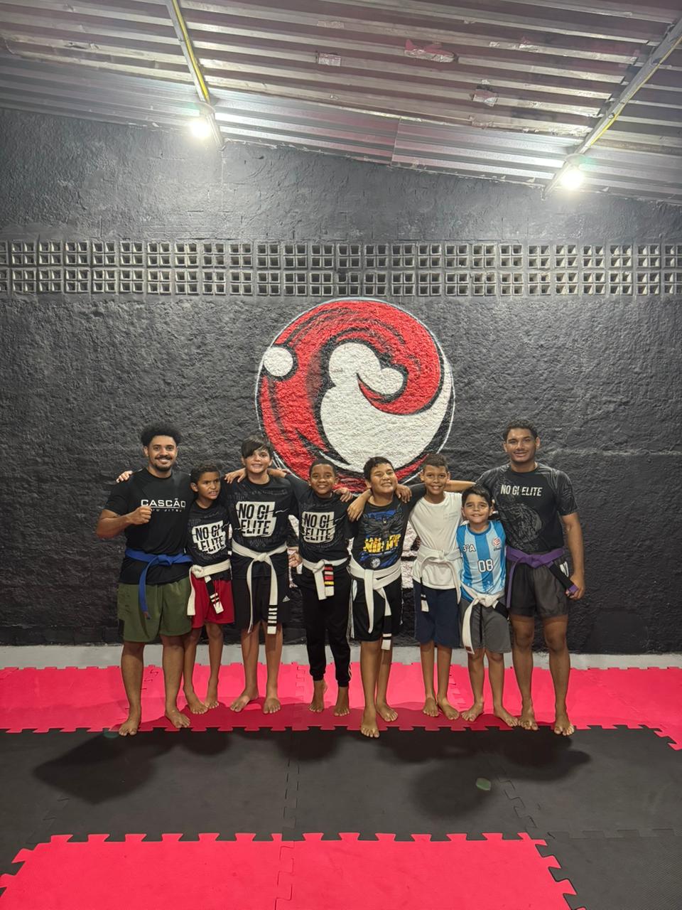 Crianças e professores da turma Kids reunidos no tatame